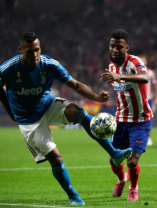 Gelandang Atletico Madrid Thomas Lemar berebut bola dengan bek Juventus, Alex Sandro pada pertandingan matchday pertama Liga Champions Grup D di Estadio Wanda Metropolitano, Rabu (18/9/2019). Juventus dan Atletico Madrid harus puas berbagi angka 2-2. (PIERRE-PHILIPPE MARCOU / AFP)