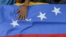 Bendera negara Venezuela yang bawa saat mengiringi pemakaman Jose Francisco Guerrero di San Cristobal, Tachira State, Venezuela (19/5). Jose tewas akibat tembakan saat ia terjebak dalam konfrontasi antara demonstran dan polisi setempat. (AFP/Luis Robayo)