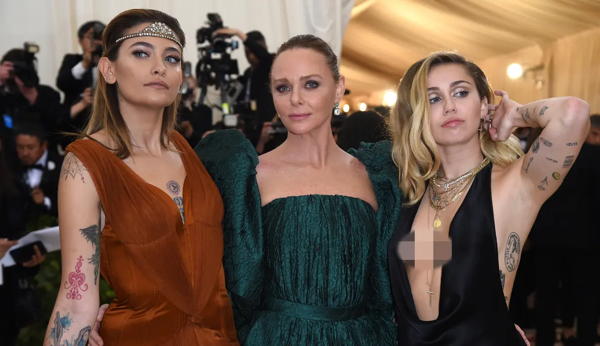 Miley Cyrus berpose bersama Paris Jackson dan Stella McCartney saat menghadiri ajang Met Gala 2018 di New York, Senin (7/5). Met Gala 2018 mengangkat tema 'Heavenly Bodies: Fashion and the Catholic Imagination'. (Evan Agostini/Invision/AP)