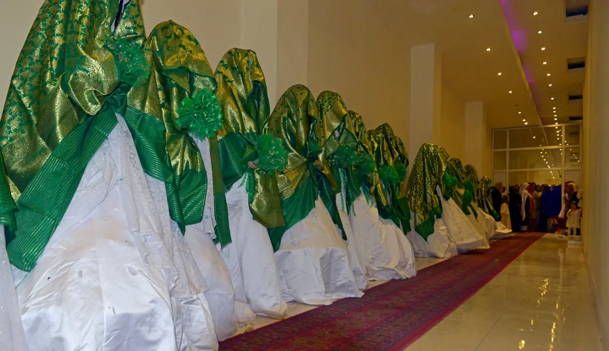 Pengantin wanita berdiri dalam aula pernikahan saat mereka menunggu dimulainya upacara pernikahan massal di Kabul, Afghanistan, 13 Juni 2022. Puluhan wanita Afghanistan yang disembunyikan dalam selendang hijau tebal dinikahkan dalam pernikahan massal yang ketat di Kabul. (Sahel ARMAN/AFP)