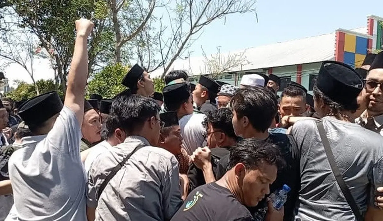 Sejumlah orang memaksa masuk ke ruang sidang pleno Muktamar ke-35 NU yang digelar di Ponpes Bahrul Ulum, Tambakberas, Jombang. (Liputan6.com/ Ahmad Apriyono)