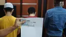 Kepala Kantor Imigrasi Jakarta Pusat Is Edy Eko Putranto memperlihatkan kartu pengungsi UNHCR milik dua dari tiga warga negara asing (WNA) yang terjaring razia Satpol PP dalam konferensi pers di Kantor Imigrasi Kelas I Non TPI Jakarta Pusat, Kamis (8/8/2019). (Liputan6.com/Immanuel Antonius)
