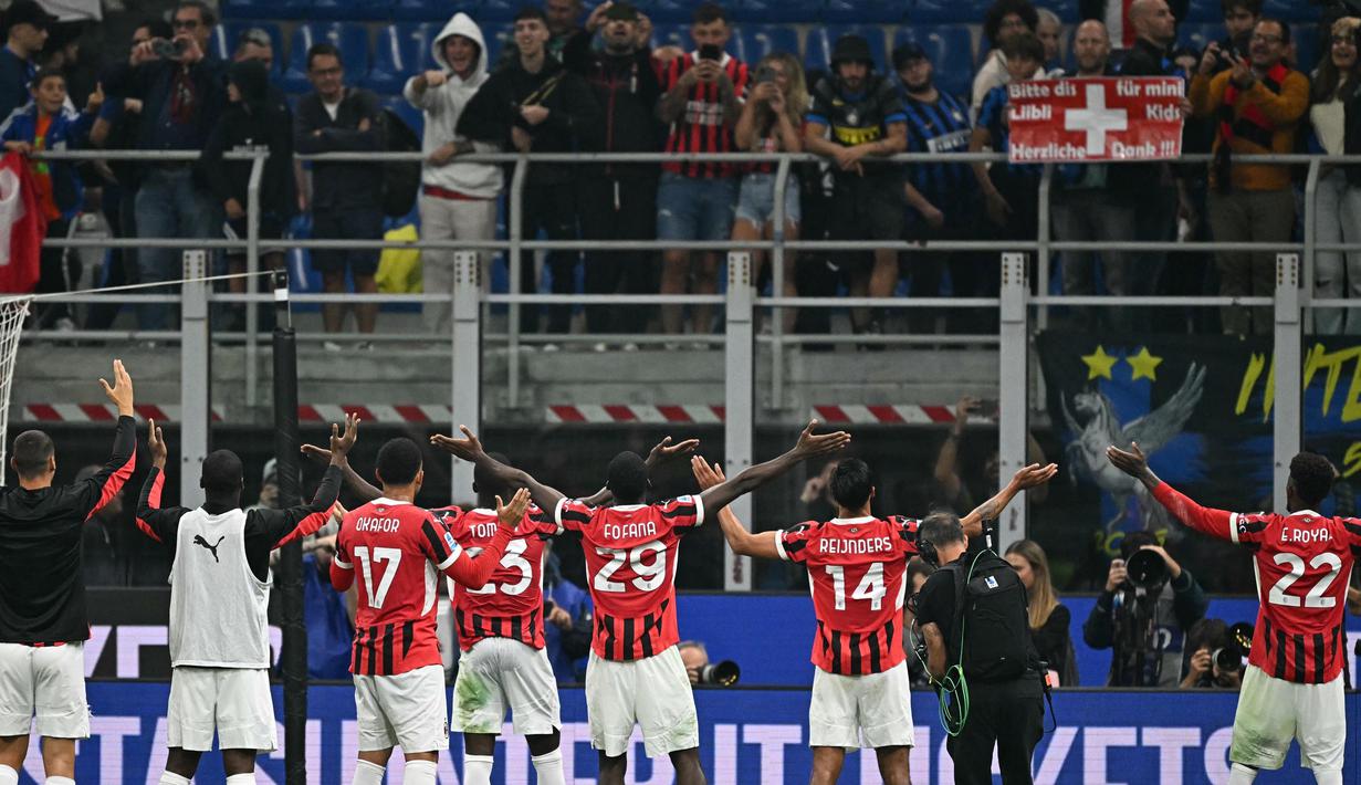 Para pemain AC Milan menyapa para penggemar usai memenangi laga Serie A Italia melawan Inter Milan di stadion Giuseppe Meazza, Milan, pada Minggu 22 September 2024 atau Senin (23/9/2024) dini hari WIB. (Gabriel BOUYS/AFP)