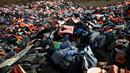 Tumpukan sampah jaket pelampung yang digunakan oleh para imigran dan pencari suaka di tempat pembuangan sampah di Mithymna, pulau Lesbos, Rabu (5/10). Para imigran mendarat di Yunani untuk mencari kehidupan baru di Eropa. (REUTERS/Alkis Konstantinidis)