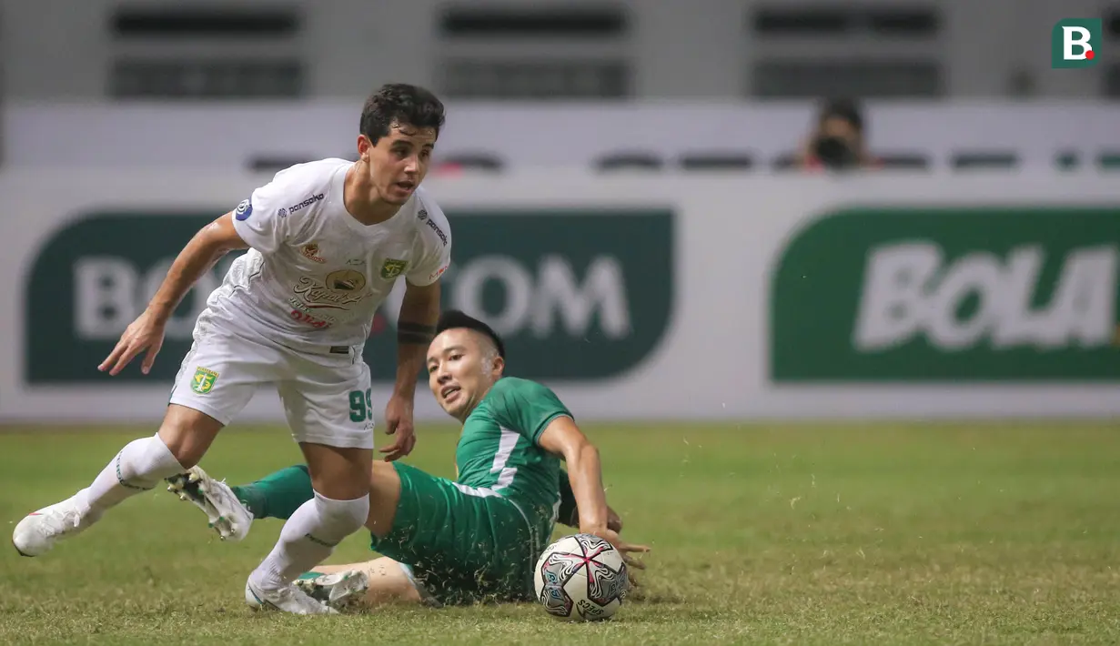 Pemain Persebaya Surabaya, Bruno Moreira Soares (kiri) berusaha melwati pemain PSS Sleman, Arthur Daniel Irawan saat laga pekan kelima BRI Liga 1 2021/2022 di Stadion Wibawa Mukti, Cikarang, Rabu (29/09/2021). (Bola.com/Bagaskara Lazuardi)