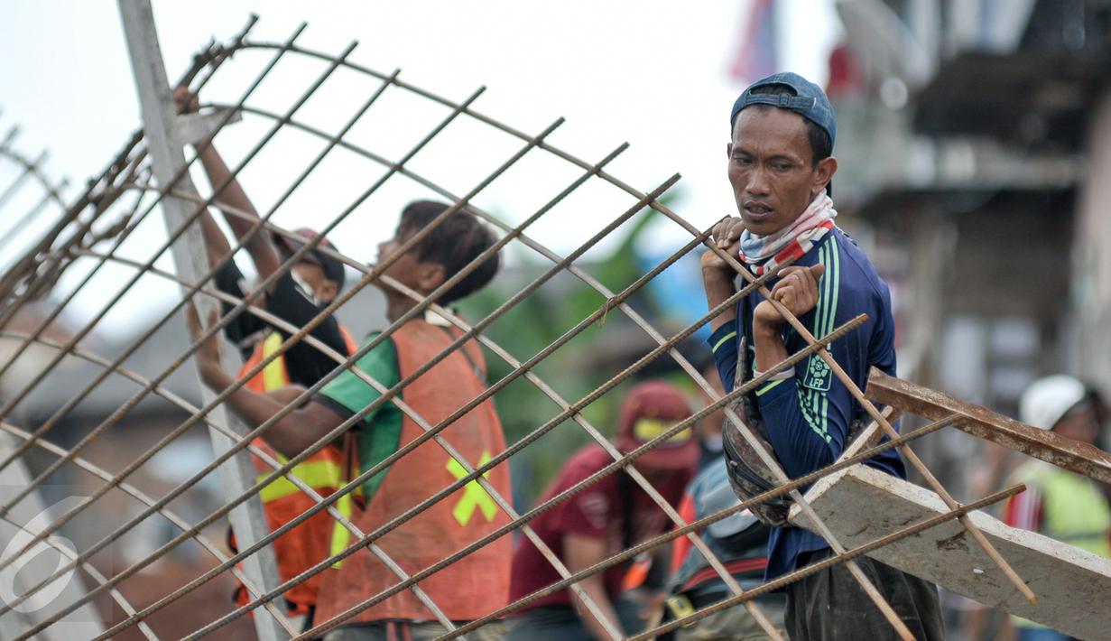 Pekerja memasang rangka untuk pengerjaan jalan di lokasi normalisasi sungai Ciliwung, Jakarta, Selasa (27/2). Proses normalisasi Sungai Ciliwung kembali dilanjutkan setelah terhenti karena meningginya air. (Liputan6.com/Yoppy Renato)