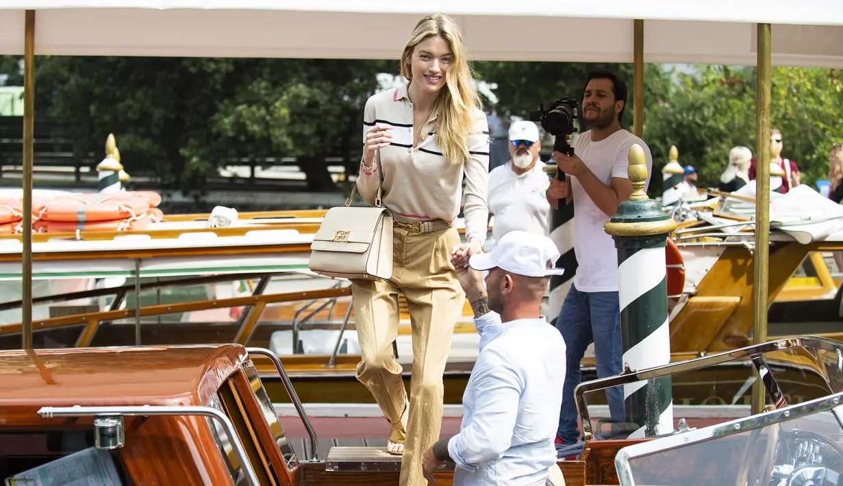 Model Martha Hunt turun dari kapal saat tiba untuk menghadiri Festival Film Venice edisi ke-76 di Venice, Italia (28/8/2019). (AP Photo/Arthur Mola)