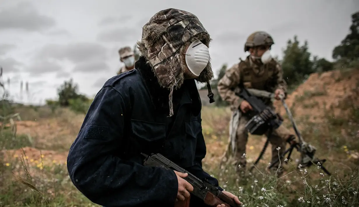 Pasukan GNA berlindung dalam pertempuran dengan Tentara Nasional Libya (LNA) di Tripoli, Libya (25/3/2020). Menteri Kesehatan pemerintah Libya yang didukung PBB Ehmid Bin Omar pada Selasa (24/3) mengumumkan infeksi COVID-19 pertama di negara tersebut. (Xinhua/Amru Salahuddien)