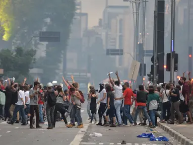 Mahasiswa bentrok dengan polisi saat memprotes kenaikan tarif bus di Sao Paulo, Brasil, Selasa (12/1). Mereka protes karena di tengah krisis ekonomi yang ditandai dan inflasi tinggi, tarif transportasi angkutan bus justru naik. (AFP PHOTO/NELSON Almeida)
