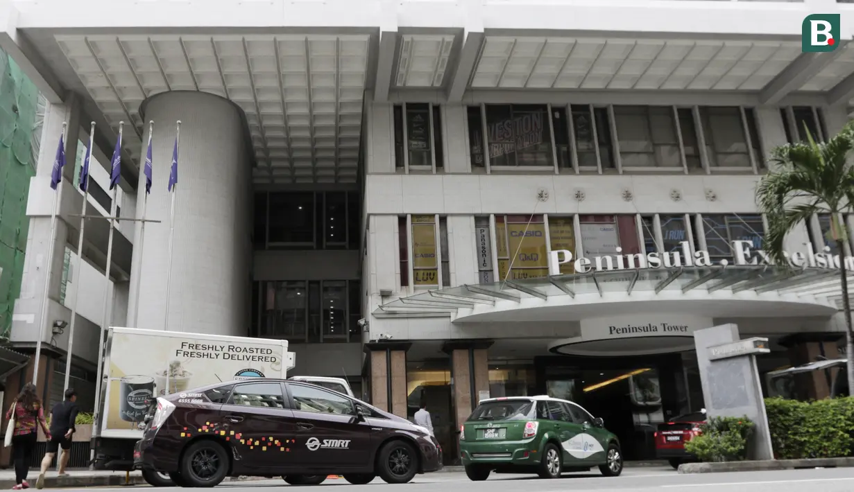Sejumlah mobil melintas di depan Hotel Peninsula Excelsior, Singapura, Rabu (7/11). Hotel bintang empat ini menjadi tempat menginap Timnas Indonesia jelang Piala AFF 2018. (Bola.com/M. Iqbal Ichsan)