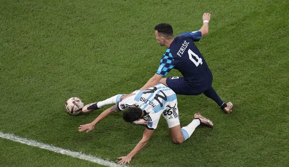 Gelandang Kroasia, Ivan Perisic dan bek Argentina Nahuel Molina memperebutkan bola selama pertandingan semifinal Piala Dunia 2022 di Stadion Lusail di Lusail, Qatar, Rabu (14/12/2022). Argentina berhasil lolos ke final setelah menang telak atas Kroasia dengan skor 3-0.  (AP Photo/Thanassis Stavrakis)
