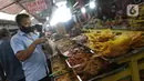 Pedagang melayani pembelian makanan khas Sumatera Barat di kawasan Food Street Kramat, Jakarta, Jumat (30/4/2021). Kawasan yang menjual beragam menu makanan khas Sumatera Barat selalu ramai dikunjungi pecinta kuliner terutama jelang waktu berbuka puasa. (Liputan6.com/Helmi Fithriansyah)