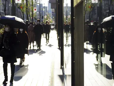 Orang-orang yang memakai masker untuk membantu mengekang penyebaran COVID-19 berjalan di sepanjang jalan perbelanjaan, Tokyo, Jepang, 29 Desember 2021. Kasus COVID-19 di Jepang meningkat lagi. (AP Photo/Eugene Hoshiko)