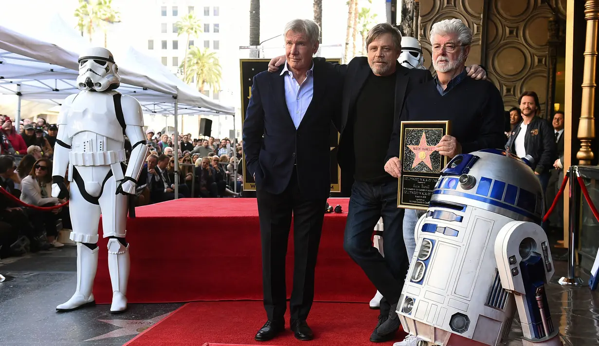 Pemeran Luke Skywalker dalam film "Star Wars", Mark Hamill berpose dengan karakter droid R2-D2 saat upacara pemberian Hollywood Walk of Fame di Los Angeles (8/3). (Jordan Strauss / Invision / AP)