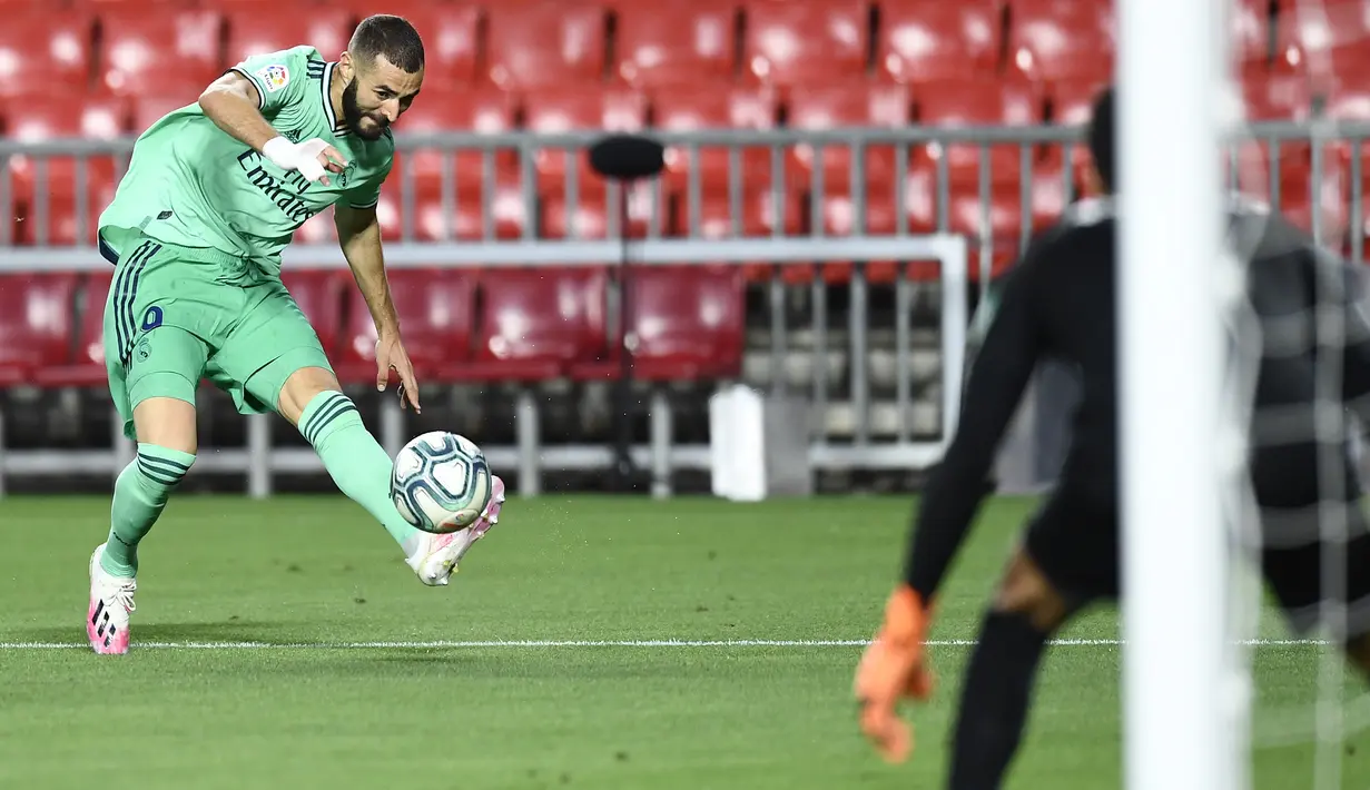 Striker Real Madrid, Karim Benzema, melepaskan tendangan ke arah ke gawang Granada pada laga lanjutan La Liga pekan ke-36 di di Estadio Nuevo Los Carmenes, Selasa (14/7/2020) dini hari WIB. Real Madrid menang 2-1 atas Granada. (AP/Jose Breton)