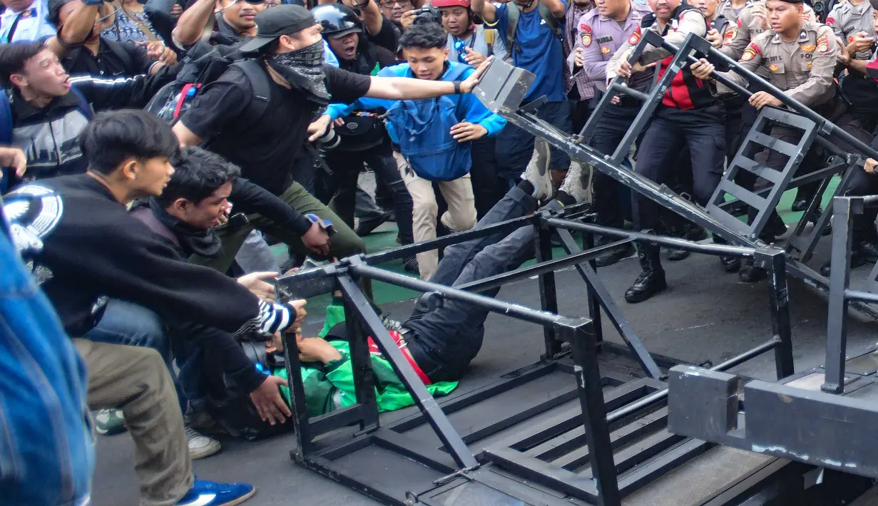 Pengunjuk rasa terlibat aksi saling dorong ketika mencoba membuka blokade aparat keamanan saat berunjuk rasa di kawasan jalan Jenderal Sudirman, Jakarta, Jumat (12/6/2026). (merdeka.com/Arie Basuki)