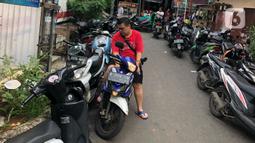 Warga parkir di sekitar Jalan Kebon Pala II, Jakarta, Selasa (25/2/2020). Banjir yang merendam kawasan tersebut menyebabkan warga mengungsikan kendaraannya ke tempat yang lebih tinggi. (Liputan6.com/Immanuel Antonius)