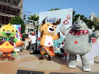 Maskot Asian Games 2018 Bhin-Bhin (kiri), Atung (tengah) dan Kaka (kanan) menyapa masyarakat saat hari bebas kendaraan bermotor di kawasan Bundaran HI, Jakarta, Minggu (1/4). (Liputan6.com/Arya Manggala)