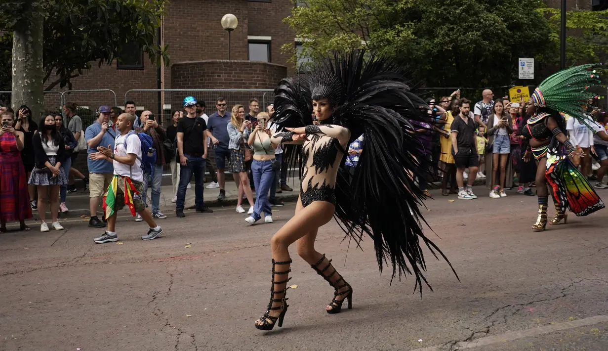Penari mengikuti Karnaval Notting Hill tahunan di London barat, Senin (29/8/2022). Karnaval yang kembali ke jalanan untuk pertama kalinya dalam dua tahun, setelah digagalkan oleh pandemi, adalah salah satu perayaan festival terbesar dari jenisnya di Eropa. (AP Photo/Alberto Pezzali)