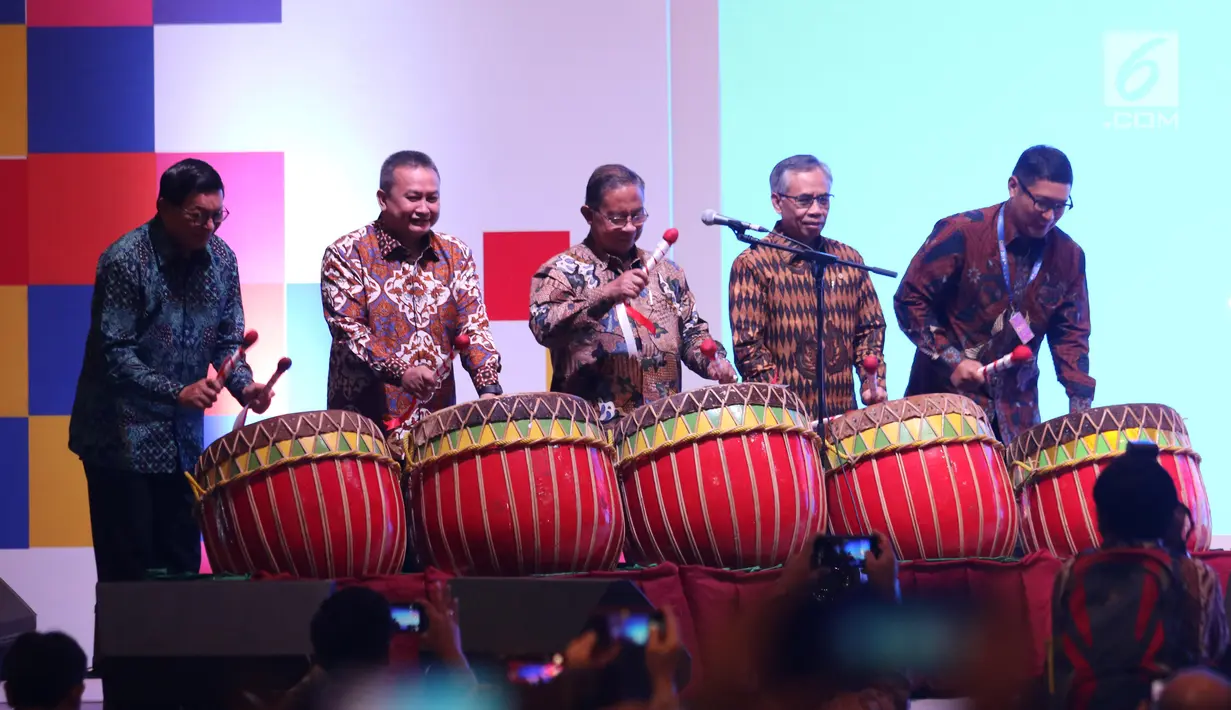 Menko Perekonomian Darmin Nasution (tengah) didampingi  Ketua OJK Wimboh Santoso (kedua kanan) dan Dirut BEI Inarno Djajadi (kiri) memukul gong saat membuka Capital Market Summit & Expo 2019 di Balai Sidang Jakarta Convention Center (JCC), Jakarta, Jumat (23/8/2019). (Liputan6.com/Angga Yuniar)