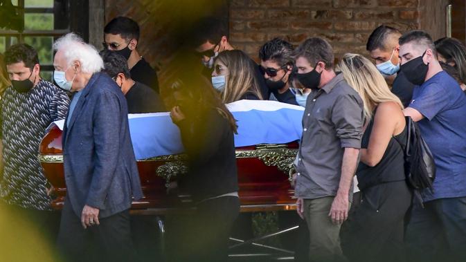Keluarga dan kerabat mengiringi peti jenazah legenda sepak bola Argentina, Diego Armando Maradona, menuju pemakaman Jardin Bella Vista, Kamis (26/11/2020) waktu setempat. Diego Maradona dimakamkan disamping makam kedua orang tuanya, Dalma dan Diego. (AFP/Ronaldo Schemidt)