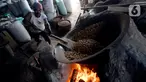 Pekerja mengolah kacang dengan media pasir di salah satu industri rumahan pembuatan kacang sangrai di Kawasan Keranggan, Tangerang Selatan, Selasa (11/8/2020). Kacang sangrai yang dipasarkan seharga Rp10.000 per kg itu mulai mengalami kenaikan pesanan dibanding bulan lalu. (merdeka.com/Dwi Narwoko)