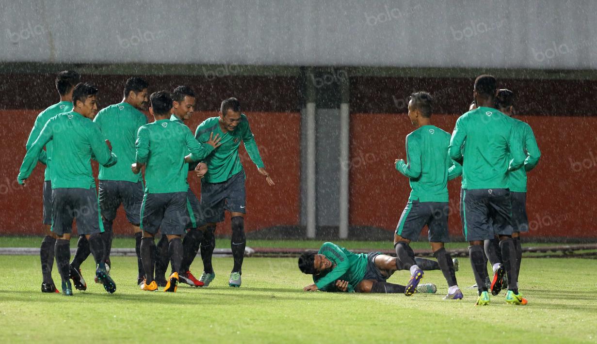 Para pemain Timnas Indonesia bercanda saat hujan deras pada sesi latihan uji coba lapangan di Stadion Maguwoharjo, Sleman, Sabtu (08/10/2016). (Bola.com/Nicklas Hanoatubun)