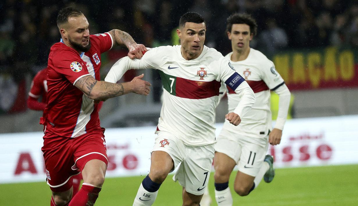 Pemain Portugal, Cristiano Ronaldo, berebut bola dengan pemain Luksemburg, Maxime Chanot, pada matchday kedua Grup J Kualifikasi Euro 2024 di Stadion Stade de Luxembourg, Senin (27/3/2023). Kapten Selecao ini membungkus dua gol, di menit ke-9, dan ke-31. (AP Photo/Olivier Matthys)