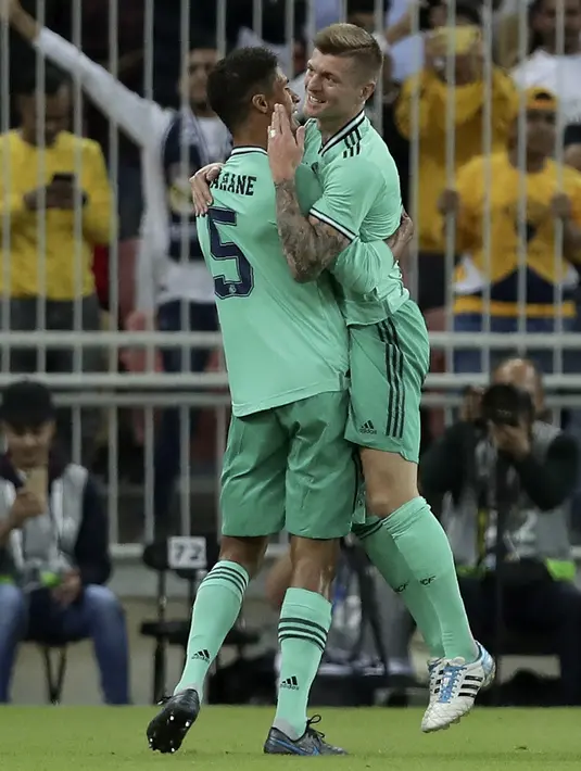 Gelandang Real Madrid, Toni Kroos berselebrasi dengan rekannya Raphael Varane usai mencetak gol ke gawang Valencia pada pertandingan semifinal Piala Super Spanyol di stadion King Abdullah di Jiddah, Arab Saudi, Rabu, (8/1/2020). Madrid menang 3-1 atas Valencia. (AP Photo/Hassan Ammar)