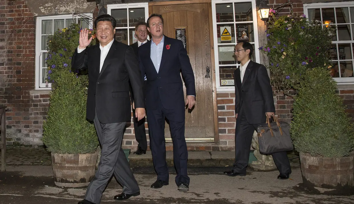Presiden Cina Xi Jinping (depan) melambaikan tangan ke kamera usai minum bir bersama di sebuah bar, Inggris, Kamis (22/10/2015). PM David Cameron mengajak Presiden China Xi Jinping untuk minum bir bersama. (REUTERS/Kirsty Wigglesworth)