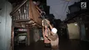 Warga menyelamatkan sepeda saat banjir menggenangi Jalan Kebon Pala, Kampung Melayu, Jatinegara, Jakarta Timur, Senin (5/2). Luapan Kali Ciliwung ini juga membuat aktivitas warga sekitar terganggu. (Liputan6.com/Arya Manggala)