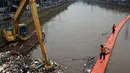 Petugas kebersihkan dibantu alat berat membersihkan sampah di Sungai Kanal Banjir Barat, Jakarta, Senin (14/11). Hujan yang terjadi di hulu Banjir Kanal Barat mengakibatkan meningkatnya debit air yang disertai sampah. (Liputan6.com/Johan Tallo)