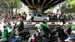 Pengendara sepeda motor berteduh di kolong flyover saat hujan mengguyur kawasan Tebet, Jakarta, Senin (14/9/2020). Kolong flyover kerap menjadi tempat berteduh bagi sebagian pengendara, meski kondisi tersebut dapat mengganggu arus lalu lintas. (Liputan6.com/Immanuel Antonius)
