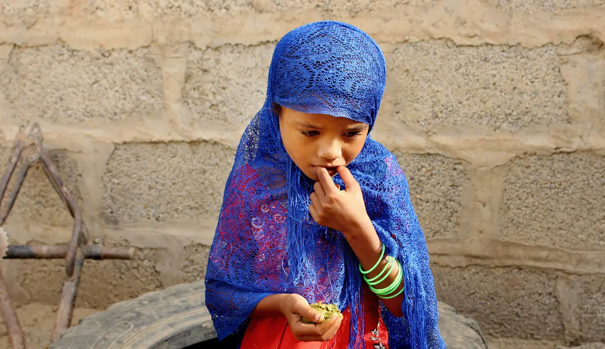 Seorang gadis makan daun rebus dari pohon anggur lokal untuk mencegah kelaparan di Distrik Aslam, Hajjah, Yaman, 25 Agustus 2018. Yaman telah hancur oleh konflik yang terus terjadi sejak awal 2015. (AP Photo/Hammadi Issa)