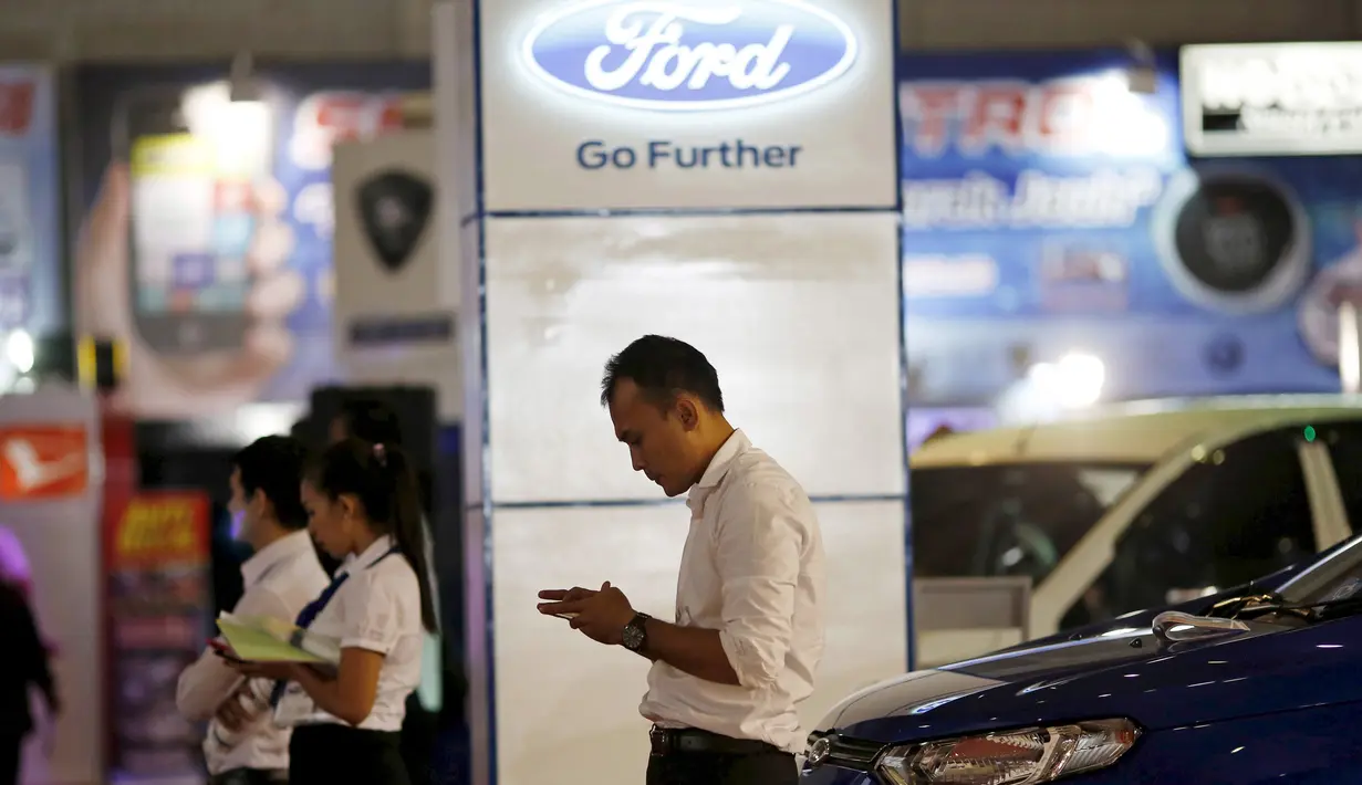 Seorang Salesman saat menunggu pelanggan di pameran mobil di Jakarta Fair, Jakarta, 30 Juni 2015. Pabrikan asal Amerika Tersebut itu tak kuat lagi berkompetisi di Indonesia dan para karyawan akan dirumahkan. (REUTERS / Nyimas Laula)