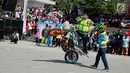 Aksi freestyle motor saat menghibur warga selama kegiatan Millenial Road Safety Festival Gorontalo, Minggu (10/2). Kegiatan ini juga diisi dengan lomba savety riding untuk umum. (Liputan6.com/Rahmad Arfandi Ibrahim)