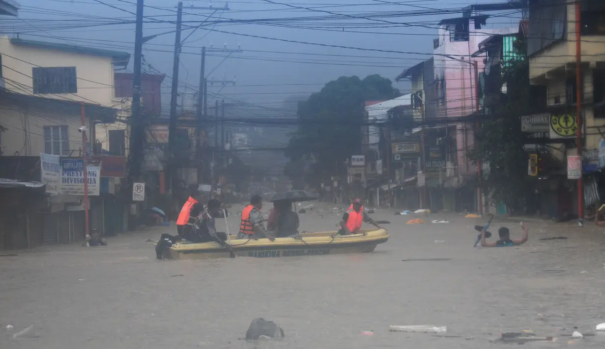 Tim penyelamat dikerahkan ke seluruh area untuk membantu mengevakuasi orang-orang dari rumah-rumah yang tergenang banjir. (Ted ALJIBE/AFP)