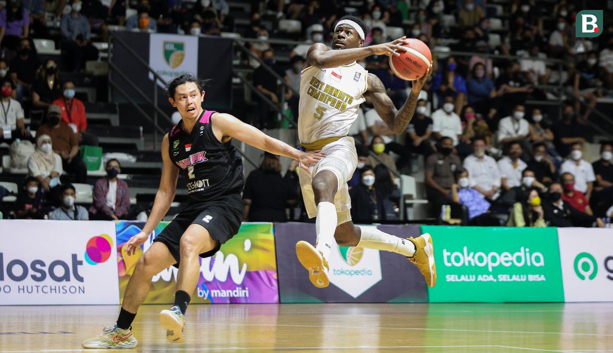 Pemain West Bandits Combiphar Solo, M. Kolawole (kanan) berusaha melewati pemain Rans PIK Basketball, O. Sanjaya saat laga pekan pertama IBL Tokopedia 2022 di Hall Basket Gelora Bung Karno, Senayan, Sabtu (15/01/2022). (Bola.com/Bagaskara Lazuardi)