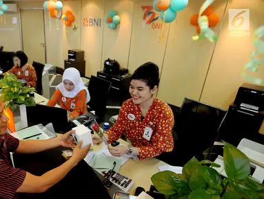 Teller memberikan bunga mawar dan souvenir kepada nasabah di Kantor Cabang BNI Tebet, Jakarta (5/7). Kegiatan dalam rangka HUT ke 72 BNI mengusung tema BNITu Digital. (Merdeka.com/Arie Basuki)