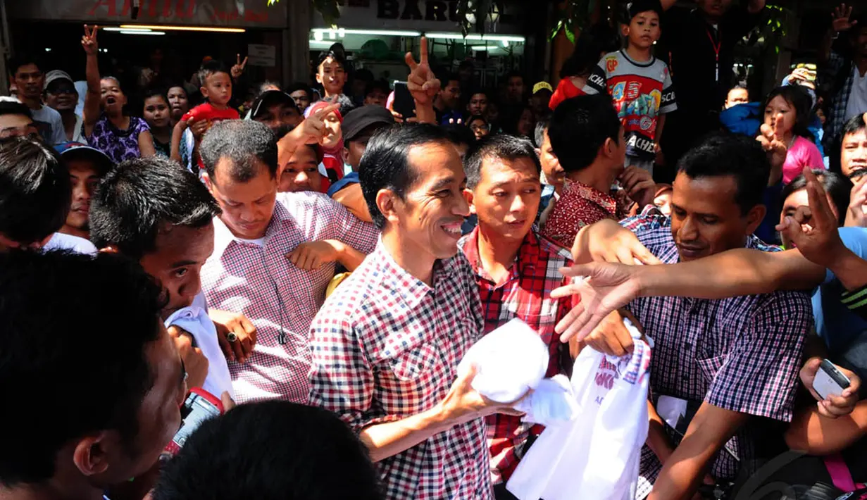 Di lokasi ini, mantan Wali Kota Solo itu membagi-bagikan kaos 'Jokowi-JK' kepada warga, Jakarta, Senin (30/6/14). (Liputan6.com/Andrian M Tunay)