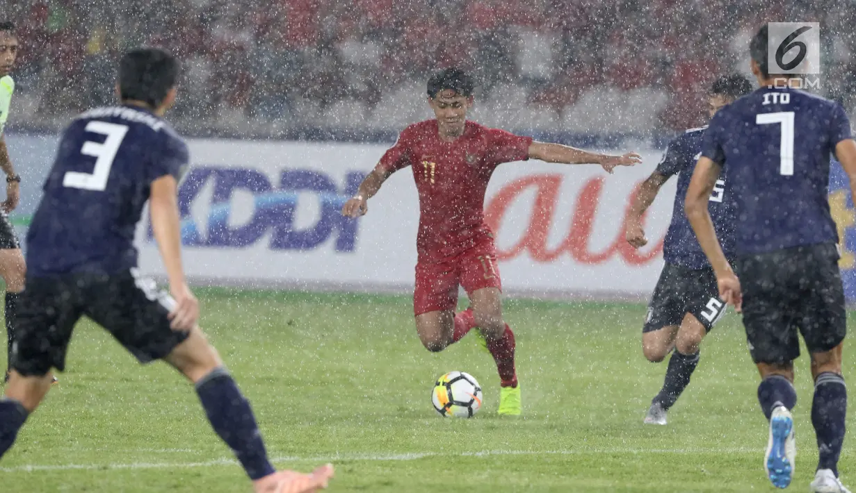 Bek Timnas Indonesia U-19, Firza Andika (tengah) mencoba menembus pertahanan adangan tiga pemain Jepang pada perempat final Piala AFC U-19 2018 di Stadion GBK, Jakarta, Minggu (28/10). Indonesia kalah 0-2. (Liputan6.com/Helmi Fithriansyah)