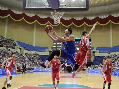 Pemain Korea Utara (merah) berusaha memblok bola dari serangan pemain Korea Selatan (biru) selama pertandingan basket pria ramah di Stadion Indoor Ryugyong Chung Ju-Yung, Pyongyang (5/7). Tim pria Korea Utara memenangkan 82-70. (AFP Photo/Kim Won-Jin)