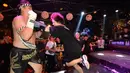 Petinju Muay Thai menahan pukulan dari seorang pengunjung pada sebuah pertandingan di bar kawasan Handan, Tiongkok, 29 Juli 2017. Pertandingan Muay Thai ini sengaja digelar untuk memberikan layanan 'pukulan gratis' bagi pengunjung yang stres. (STR/AFP)
