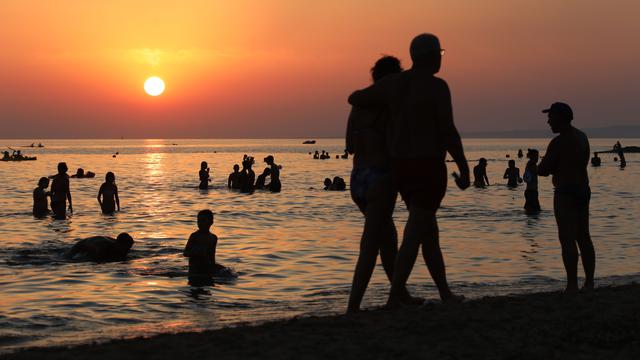 Berenang sambil menikmati keindahan sunset di pantai Italia