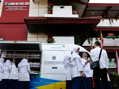 Siswa SMPN 49 Jakarta antusia membaca buku mobil perpustakaan keliling di halaman sekolah, Jakarta, Jumat (4/9/2015). Sebelumnya sekolah SMPN 49 mengalami kebakaran dan menyebakan ruangkan perpustakaan ludes terbakar. (Liputan6.com/Yoppy Renato)