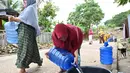 Warga yang menempati pemukiman di dataran tinggi Aceh setelah bencana tsunami 2004 mendapat distribusi air dari kepolisian setempat di Neuheun, Aceh Besar, 4 Oktober 2023. (Chaideer Mahyuddin/AFP)