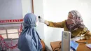 Petugas memeriksa suhu tubuh warga yang akan menjalani vaksinasi COVID-19 dari Pfizer di Puskesmas Lebak Bulus, Jakarta, Senin (23/8/2021). Sebanyak 1.560.780 dosis vaksin COVID-19 Pfizer tiba di Indonesia pada 19 Agustus 2021 melalui skema pembelian langsung. (Liputan6.com/Faizal Fanani)