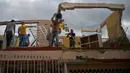 Sejumlah warga membersihkan puing-puing di sebuah bangunan setelah badai tornado menghantam Regla, Kuba (28/1). Akibat bencana tersebut tiga orang tewas dan 173 orang lainnya luka-luka. (AP Photo/Ramon Espinosa)