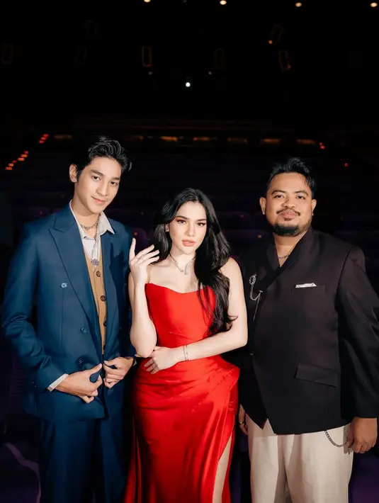 Gaun merah ini dipadu kalung berlian struktur tegas dan open toe heels silver yang glamor [@davinakaramoy]