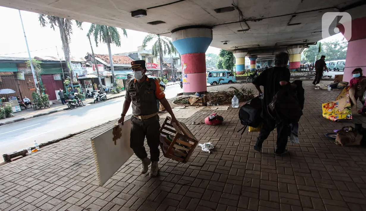 Petugas Satpol PP melakukan razia kepada para tunawisma di bawah flyover Jatinegara, Jakarta Timur, Senin (19/7/2021). Razia ini merupakan upaya dari Kecamatan Jatinegara di kawasan Kampung Melayu untuk bersih dari tunawisma yang sering tidur dan berjualan.  (Liputan6.com/Johan Tallo)